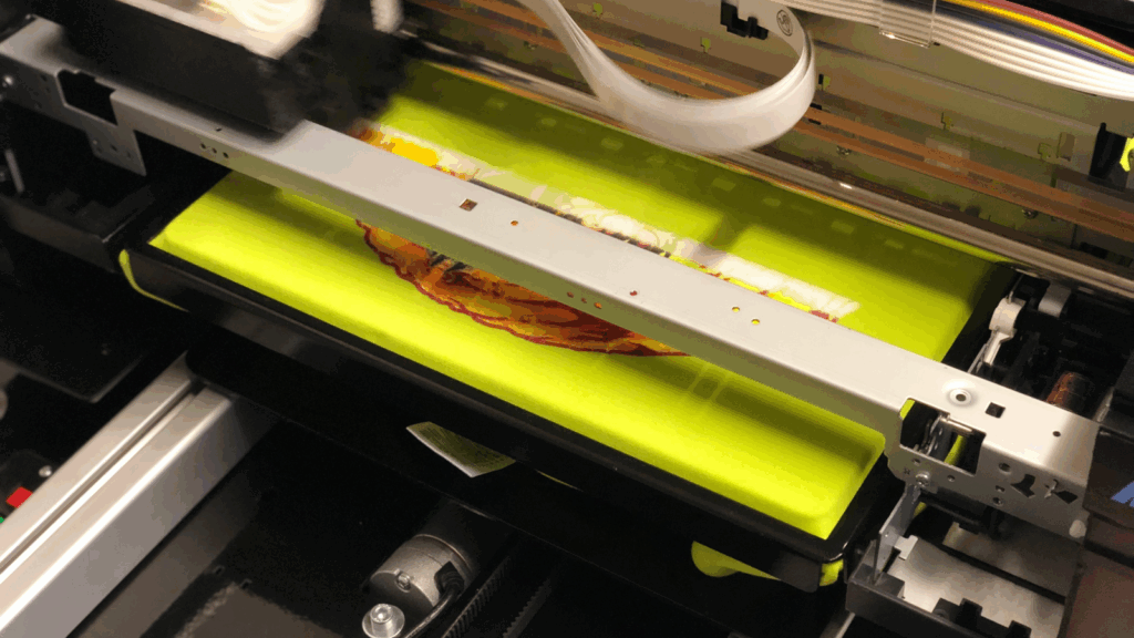 A direct-to-garment (DTG) printer in the process of printing.