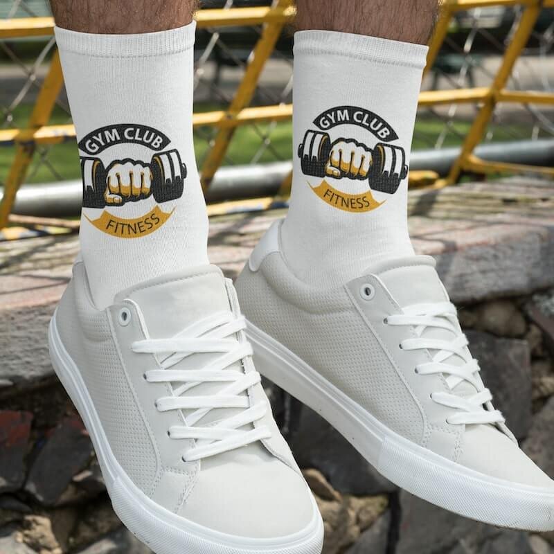 A man wearing a pair of custom socks with a fitness-themed logo.