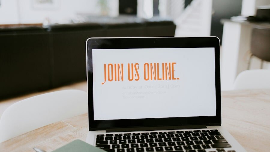 A laptop with the text “JOIN US ONLINE” on the screen.