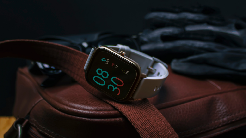 A smartwatch lying on the side on top of a leather bag.