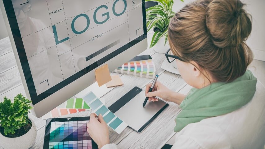 Woman working on a logo design at her computer.