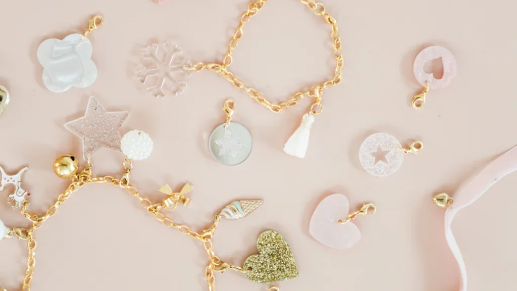 A pink and gold bracelet adorned with various charms, showcasing a blend of elegance and playful design.