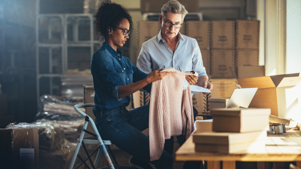 Two people looking at the quality of a shirt.
