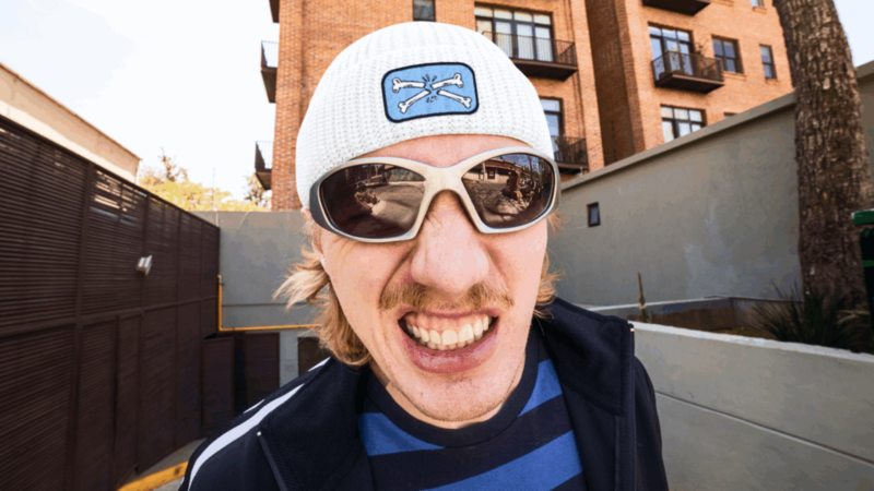 A man wearing a white beanie hat and sunglasses.