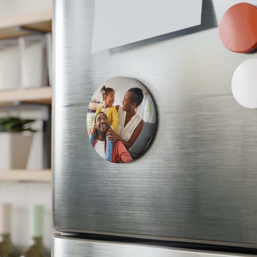 A round fridge magnet with a photo of a happy family.