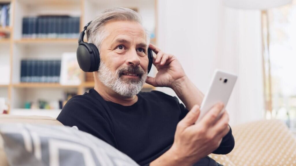 A man listening to a podcast through his headphones.