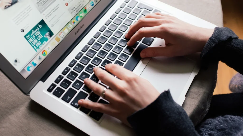 A woman typing on a laptop keyboard, learning how to do Pinterest affiliate marketing.