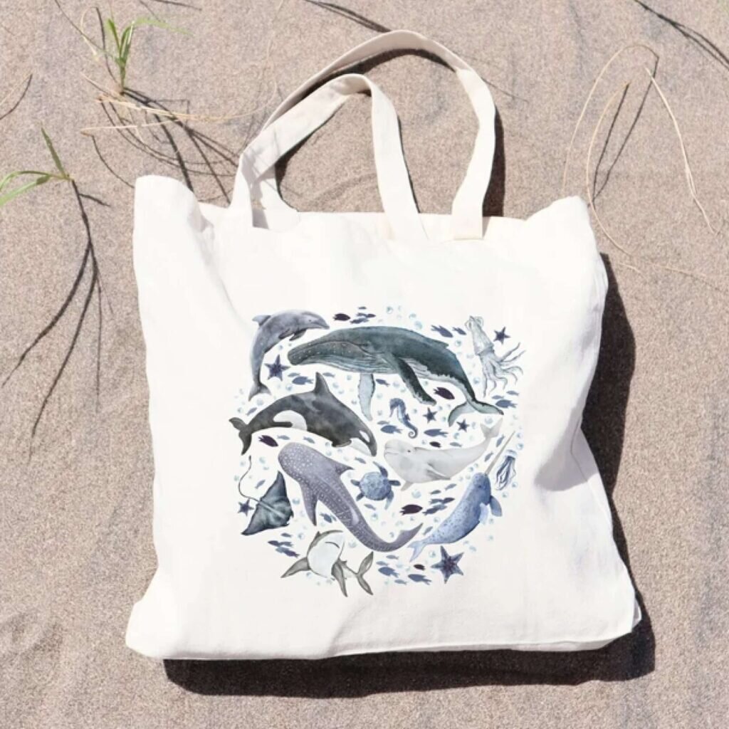 A tote bag with various aquatic creatures, whales, seals, seahorses, and more.