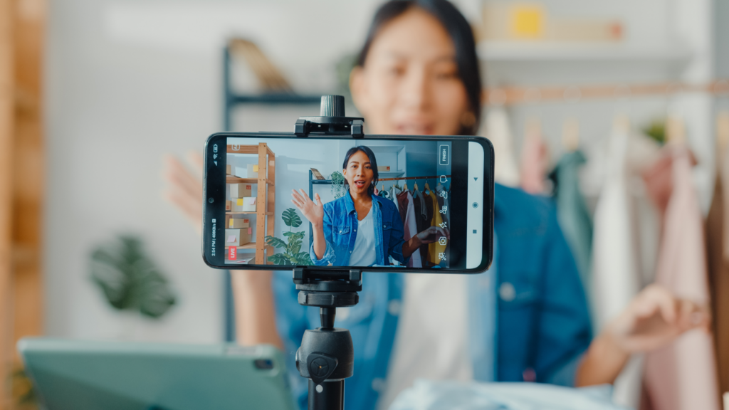 A woman live streaming using a mobile phone.