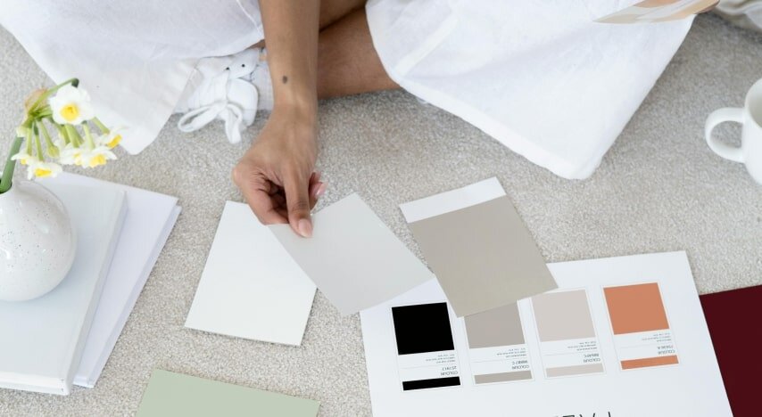 A woman selecting color palettes for branding a business.