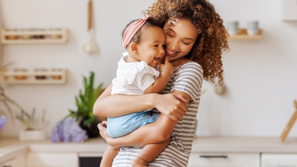 A woman gently cradles a baby in her arms, showcasing a tender moment of care and affection.