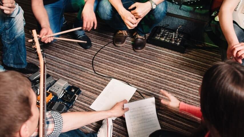 A band checking their sheet music and preparing for band practice.
