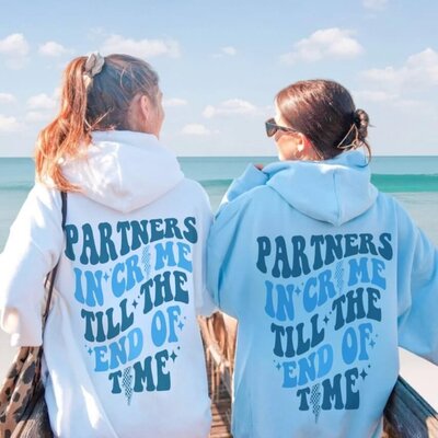 Two besties wearing matching hoodies that say "Partners in crime till the end of time."