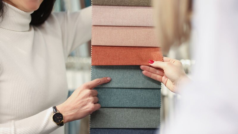 A stack of garments made from different types of polyester blend fabrics.