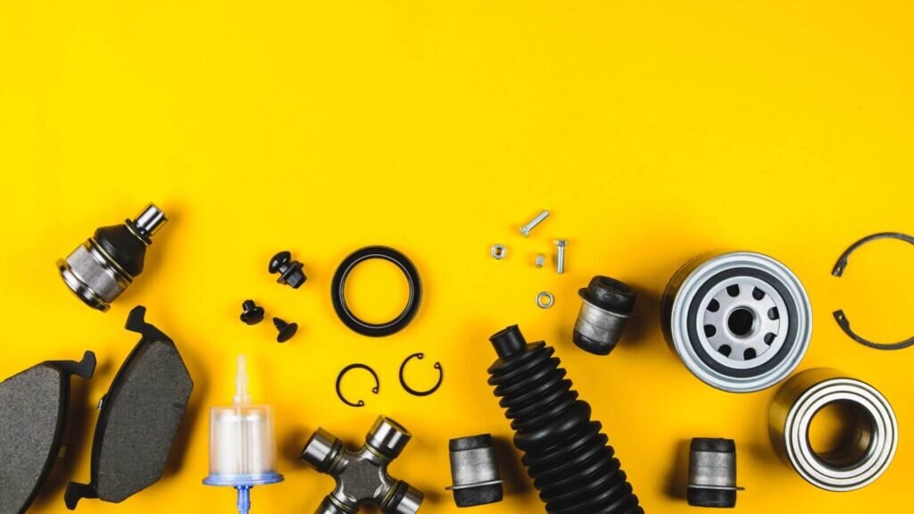 A collection of various car parts on an orange background.