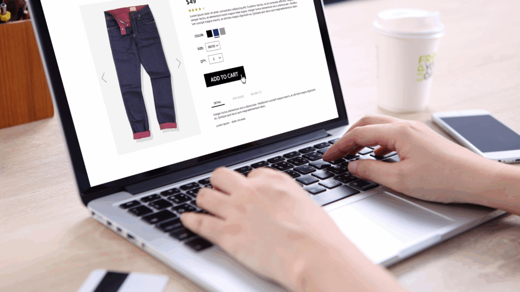 A person using a laptop to buy jeans online.