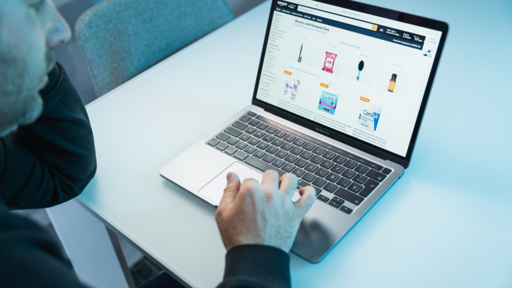 A man sitting in front of a laptop with Amazon’s product page on the screen.