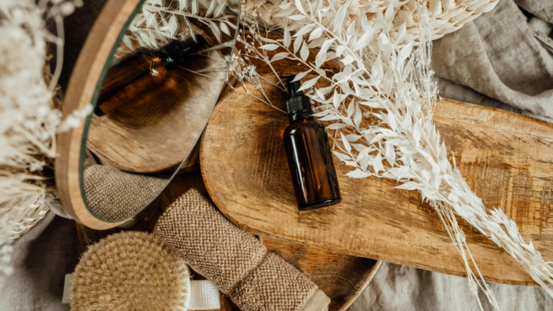 An eco-friendly beauty product on a wooden board surrounded by different bathroom accessories.
