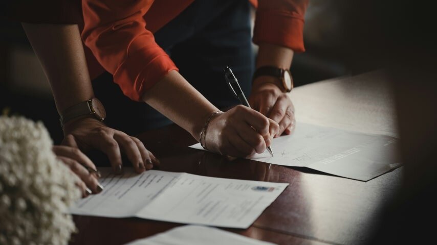 A person signing a piece of paper.