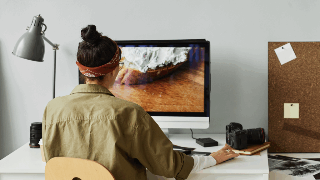 A photographer editing images on a large monitor.