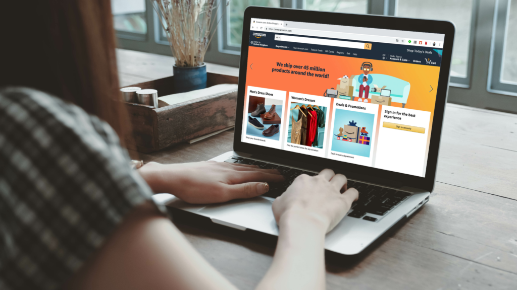 A blurred silhouette of a woman sitting in front of a laptop with Amazon’s homepage on the screen.