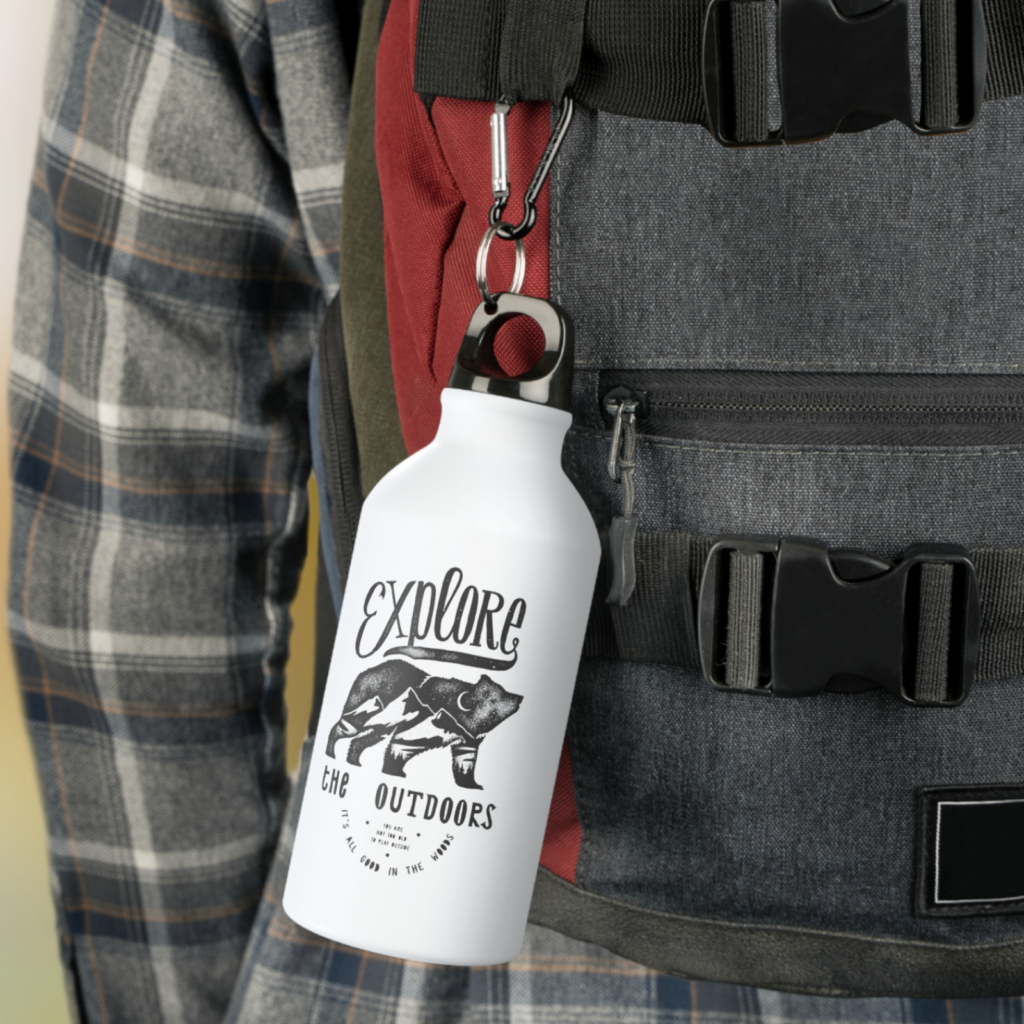 A custom “Explore the outdoors” water bottle hanging from a backpack.