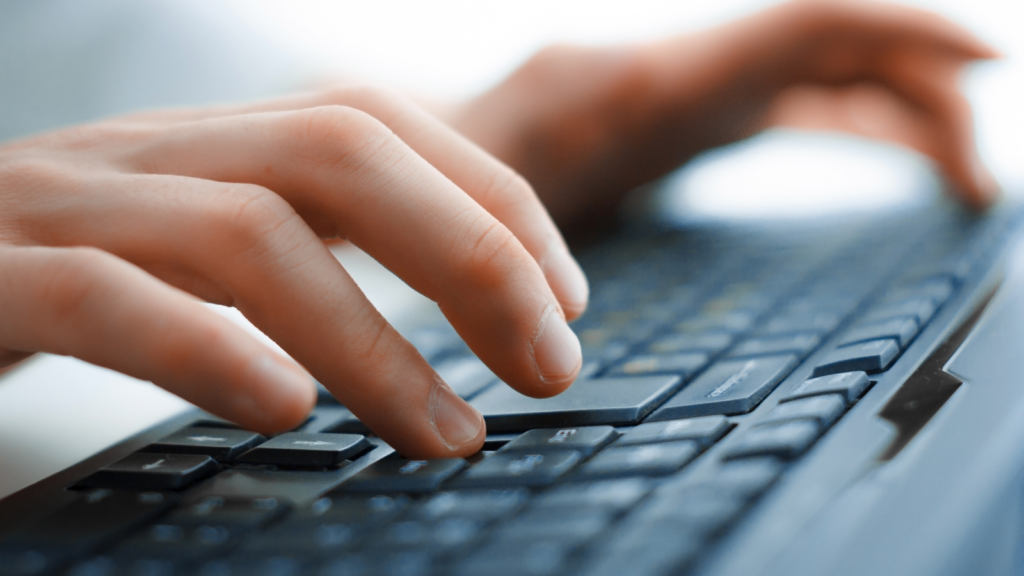 Hands typing on a keyboard.