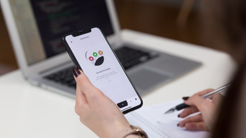 A hand holding phone with text “NO NOTIFICATIONS”.