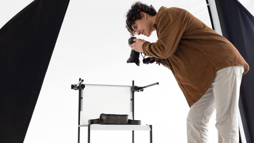 A man taking professional product photos in a studio.