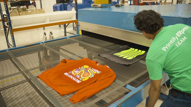 A person using screen printing to create a custom t-shirt.