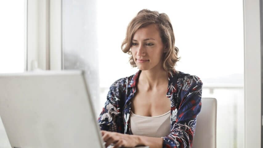 A woman looking at a laptop screen and searching how to find suppliers.