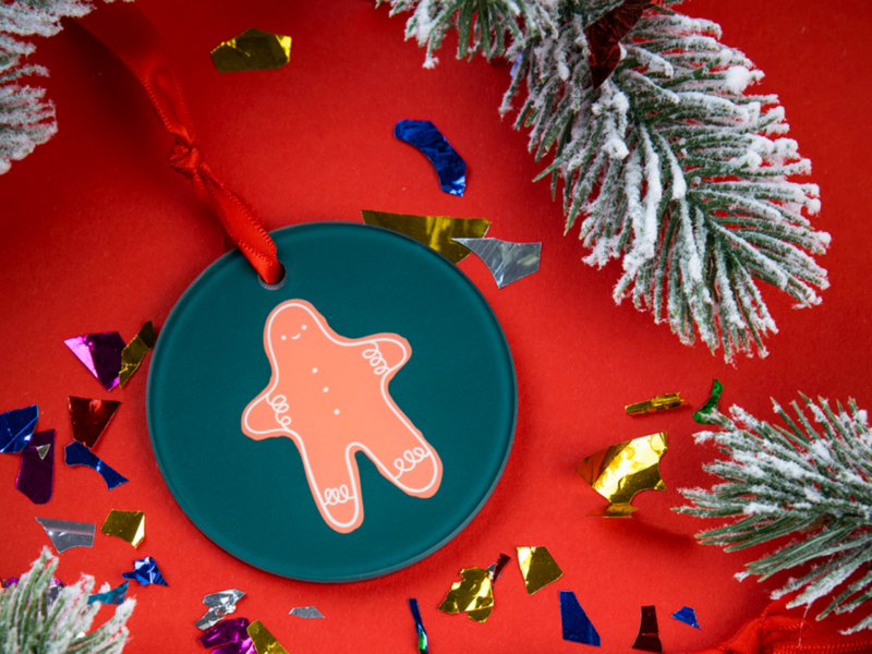 Ornaments: A green custom ornament featuring a cheerful gingerbread man, perfect for holiday decorations.