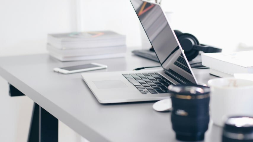 A laptop and other gadgets on a table.
