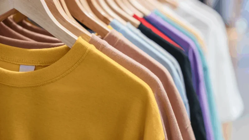 Different-color t-shirts on hangers.