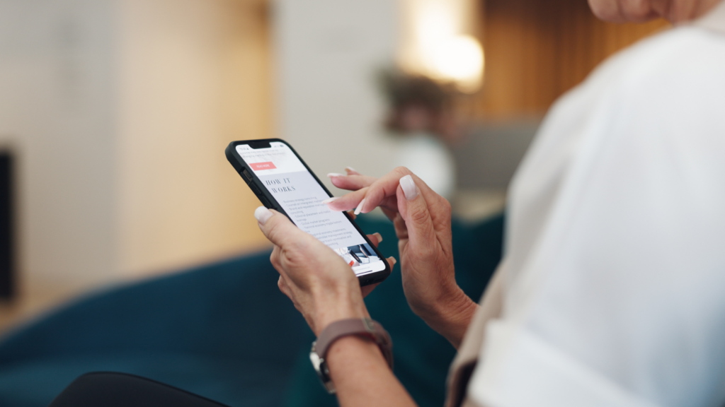 A woman engaged with her smartphone, diligently sending an email while seated comfortably.