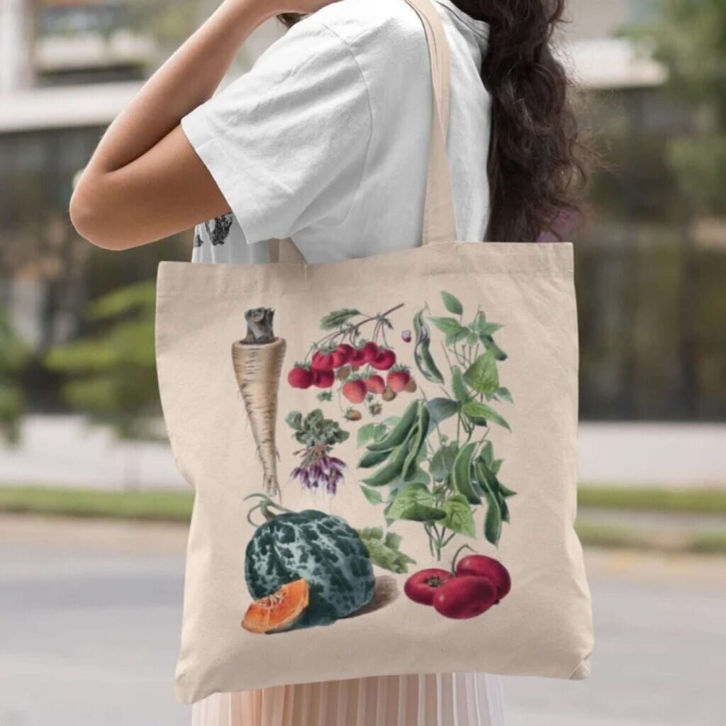 A tote bag with artistic drawings of berries, fruits, and vegetables.