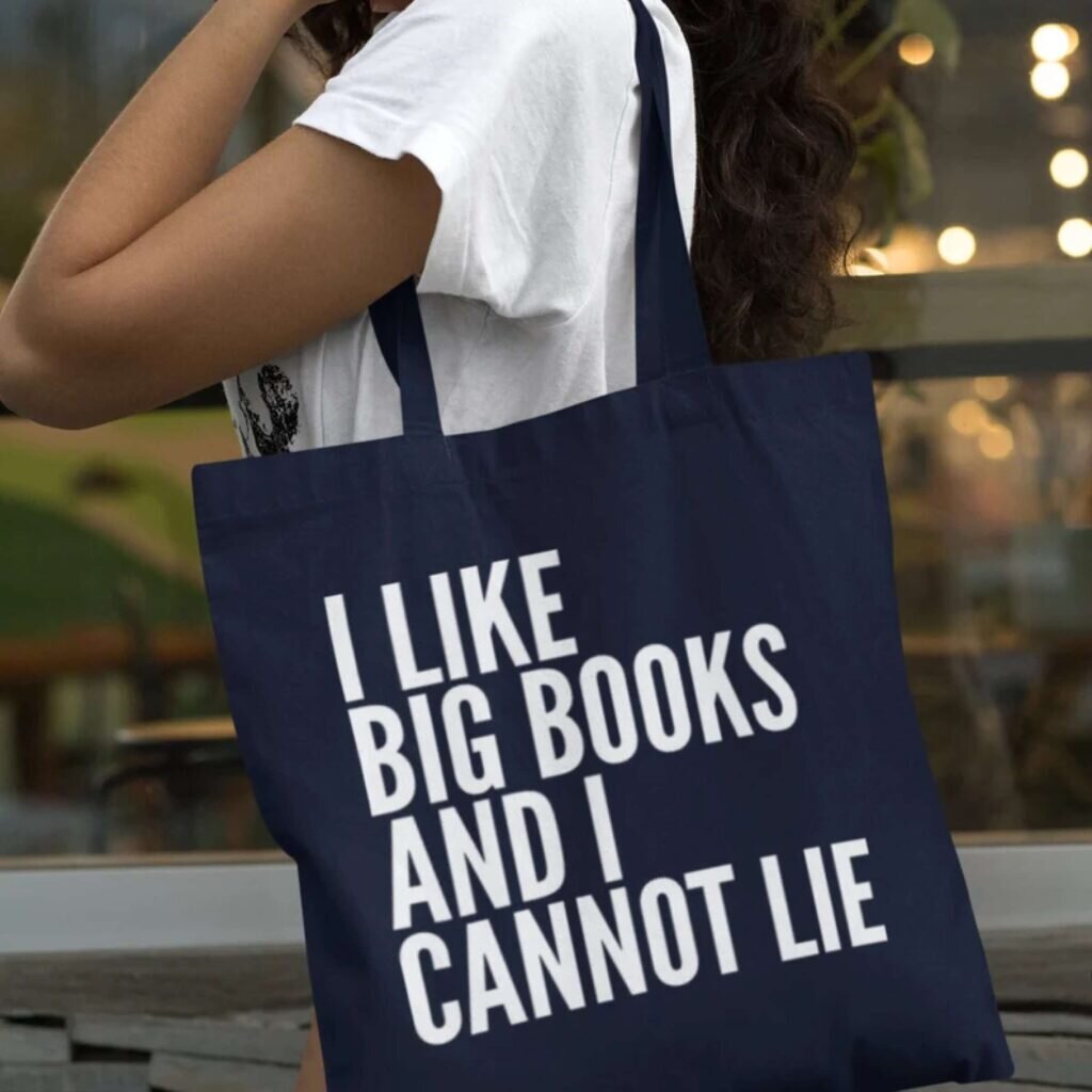 A blue tote bag with the text “I like big books and I cannot lie.”