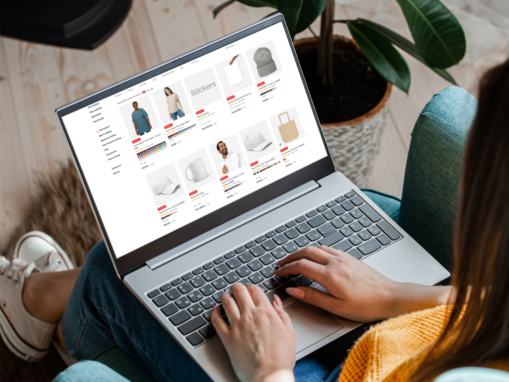 A woman scrolling through Printful’s web page using a laptop.