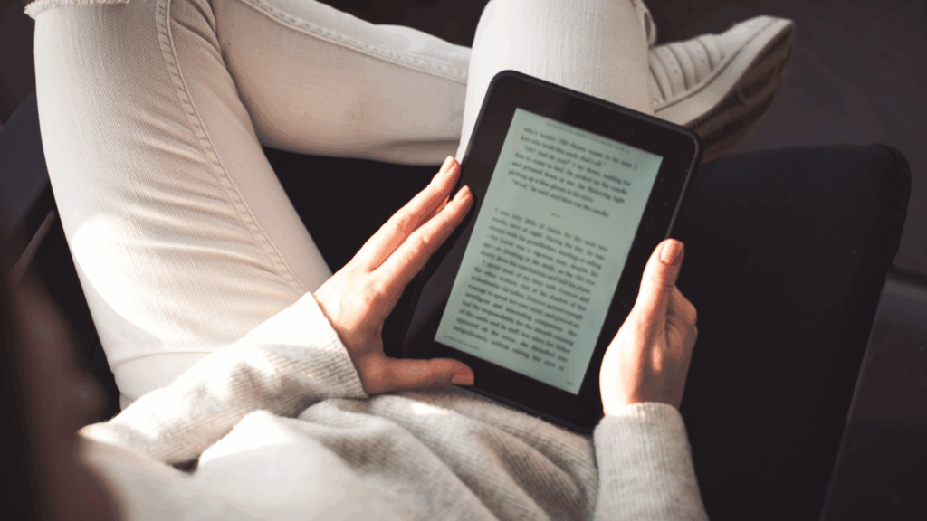 A person reading a book on a Kindle.