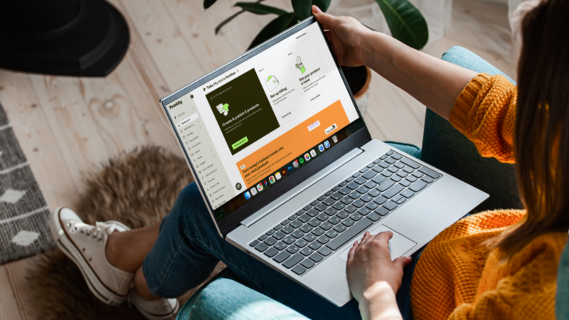 A woman is using a laptop with Printify’s admin panel on the screen.