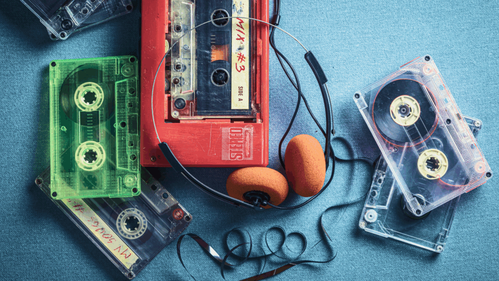 An old cassette player with headphones and various audio equipment arranged on a surface.