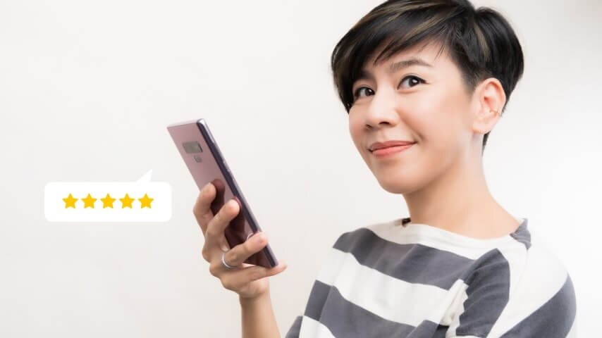 A woman leaving a five-star product review on her phone.