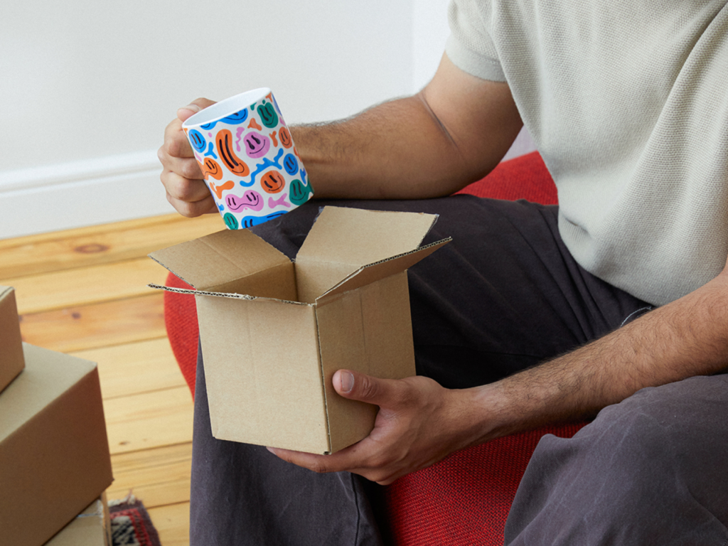 A man relaxes on a couch, cradling a new coffee mug.