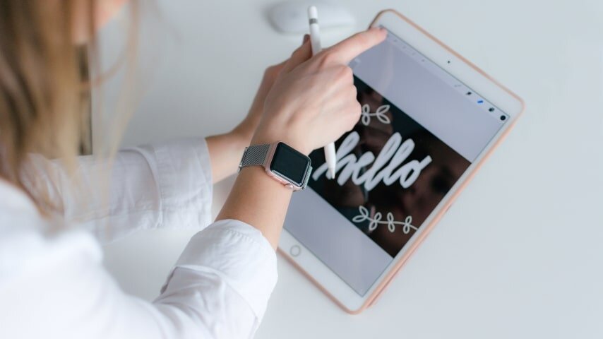 A woman creating graphic designs using a tablet.