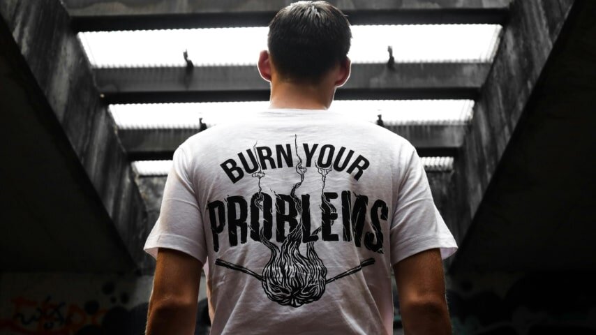 A man wearing a white t-shirt, shot from the back.