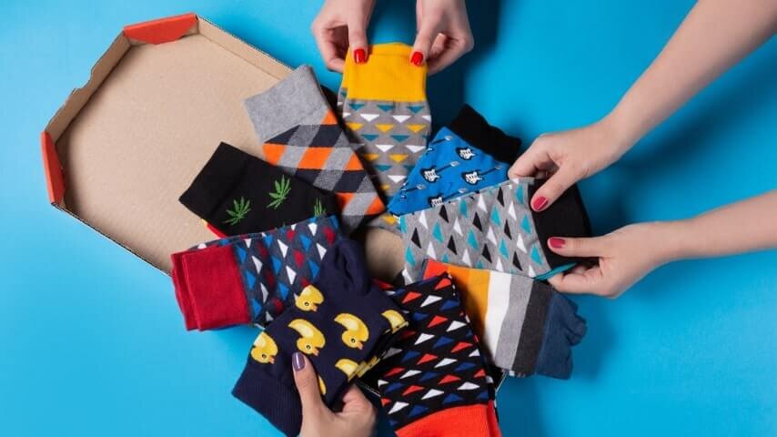 People looking at a collection of different sock types and designs.