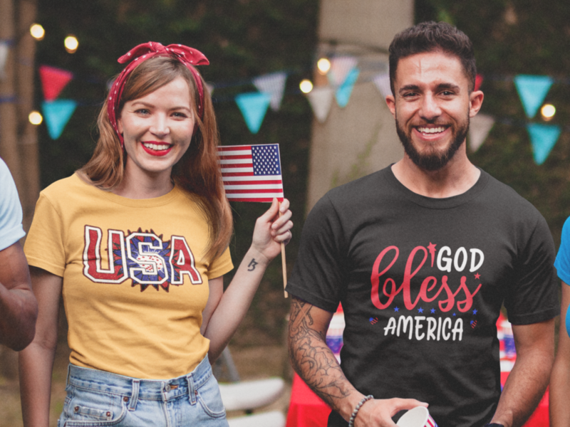 A smiling man and woman wearing a black and red t-shirt with custom 4th of July-themed prints.