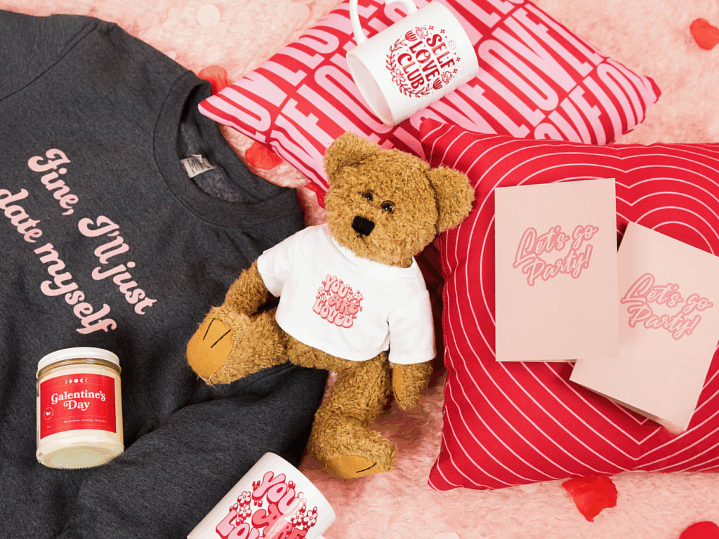 A Valentine’s day-themed swag bag with a hoodie, toy bear, pillows, scented candles and mugs.