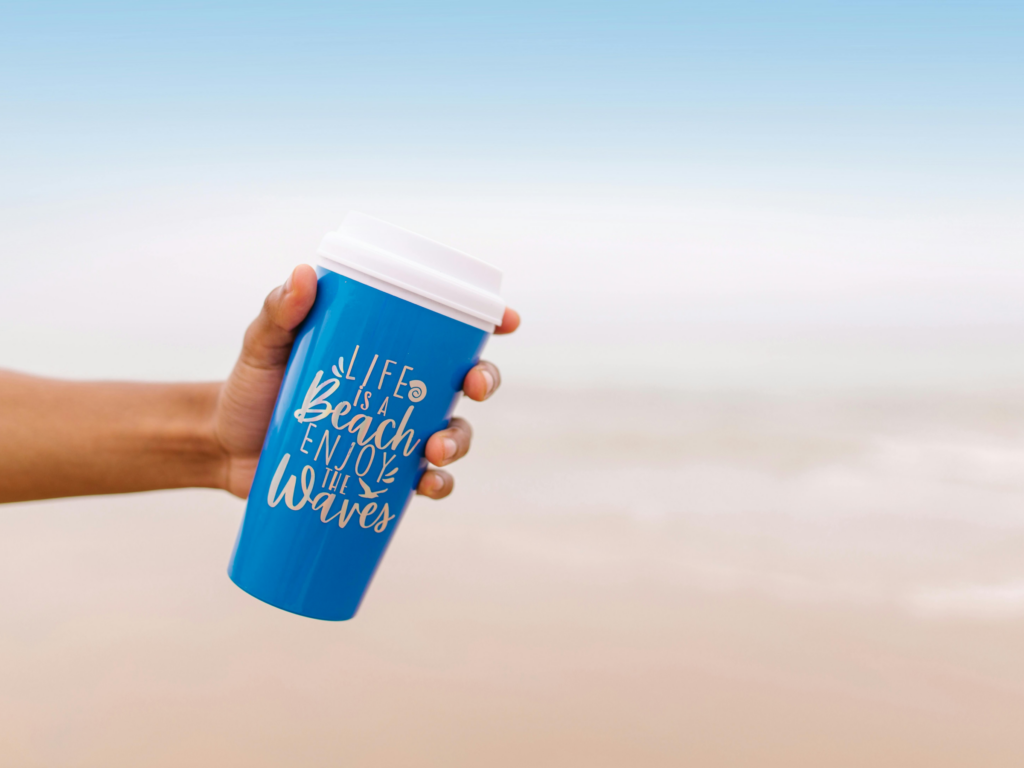 TravelMugs: A hand gripping blue travel mug mockup, showcasing its sleek design and vibrant color against a neutral background.