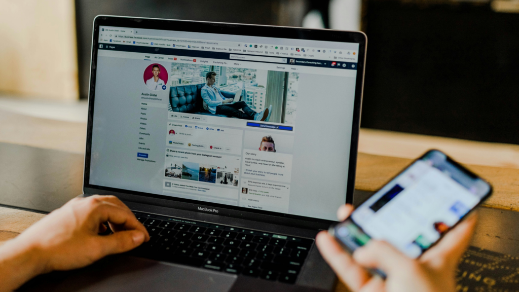 A person using a laptop and a mobile phone and doing social media marketing.